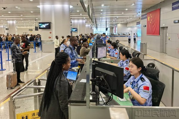 移民管理警察为浦东机场旅客办理边检手续-李宇航摄