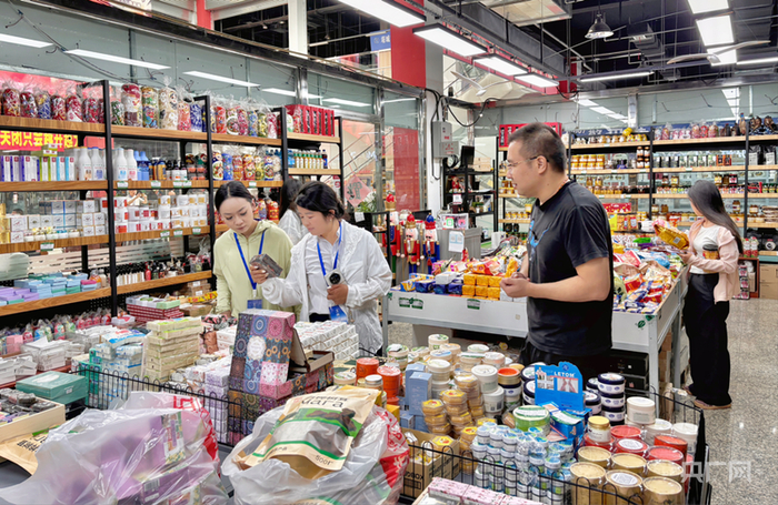 大黄蜂商行工作人员在向游客介绍商品情况（央广网记者  梁瑜琳  摄）
