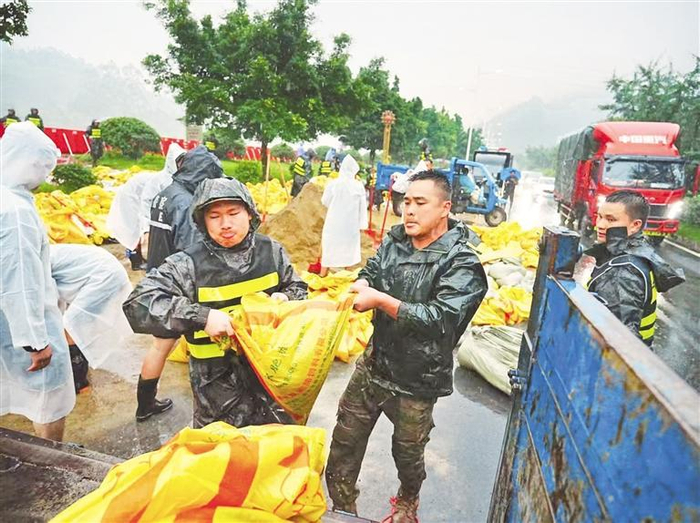 榕江县民兵杨进勇（右二）奋战在抗洪抢险一线。  （受访者供图）