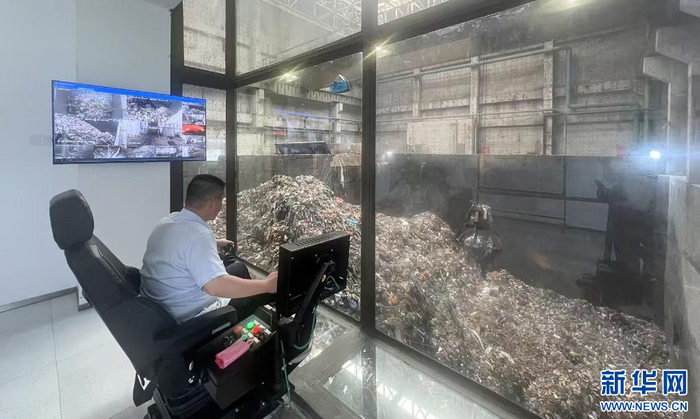 在江西省寻乌县能源生态园，工作人员正操作机械抓手处理生活垃圾。新华网 王晓震 摄