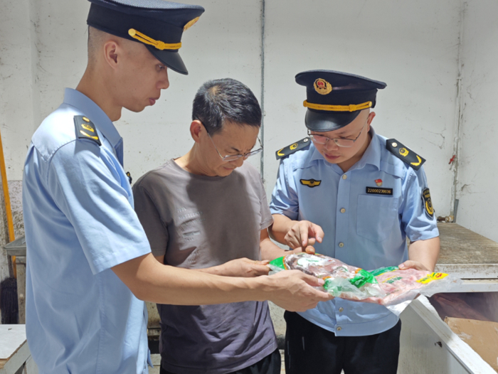 7月25日，执法人员在一家销售企业开展肉制品质量检查。