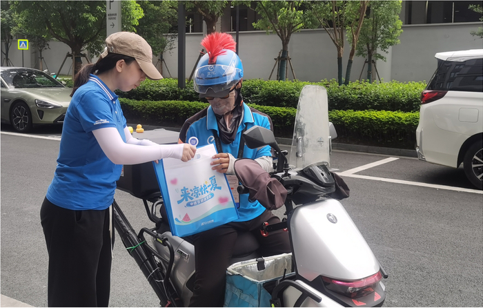 图:工作人员为外卖小哥送上清凉礼包