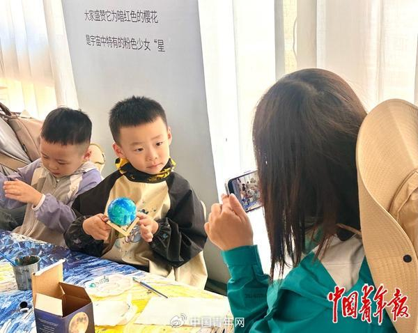 5月23日，宁夏中卫沙坡头，青少年游客在手工制作“蓝色星球”。中青报·中青网记者 焦敏龙/摄