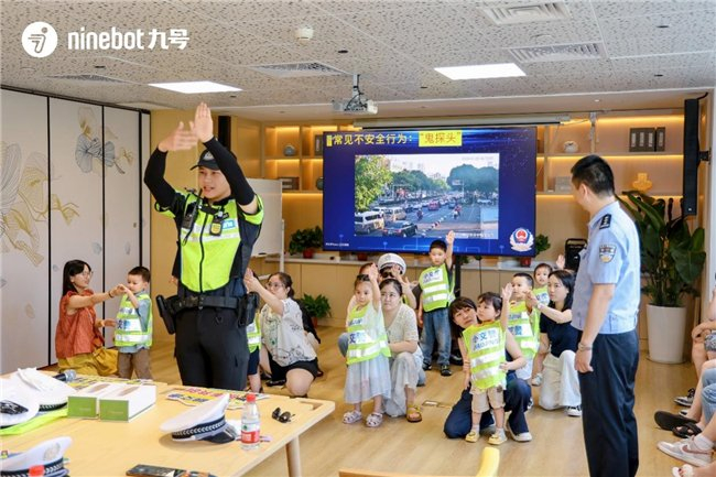图：常州市民跟着常州交警的示范动作，大家铆足劲一起学