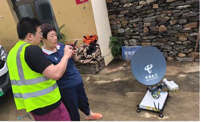 中国电信工程师在黄峪口村调通信号并教村民如何使用。受访者供图