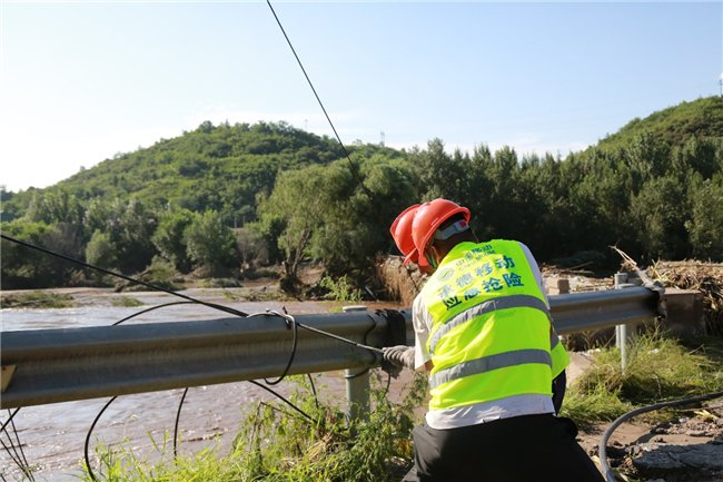 图为承德移动抢修人员在远程对讲机调度下抢修跨河光缆