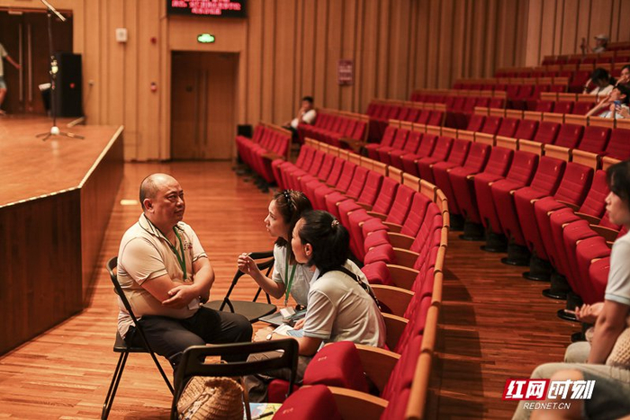 排练现场，刘雨田和德清公益工作人员在讨论展演工作。