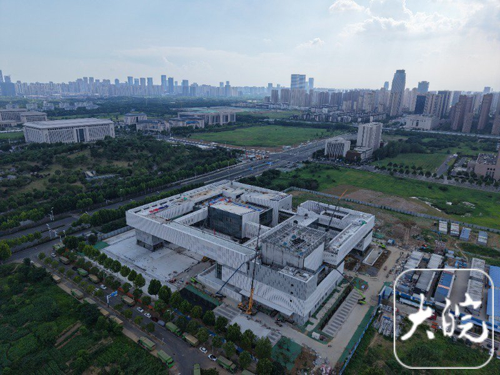 　　曲臂车停放在外墙边，有工人正在登高作业。
