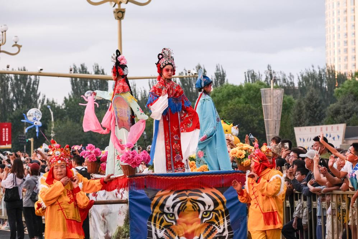 7月29日，在内蒙古赤峰市，内蒙古自治区非物质文化遗产抬阁花车与游客互动。 新华社记者 马金瑞 摄