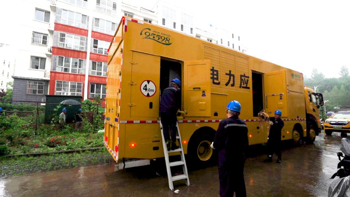 ▲7月27日，国网冀北承德供电公司双滦区供电中心双塔山供电所员工在大龙庙小区用发电车保障小区临时用电。魏明良 摄