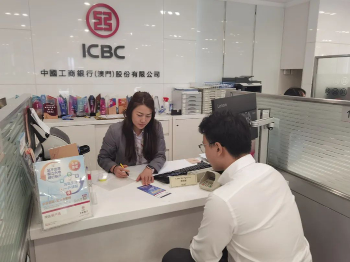 图为澳门市民何先生在工银澳门置地总行营业部办理开户手续。
