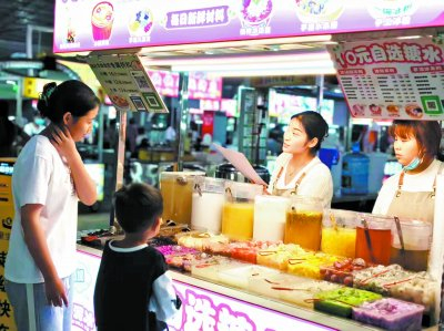     ▲ 龙陵华富夜市，“10元自选糖水”摊位上的各类新鲜水果吸引顾客前来选购。段彬艳/摄