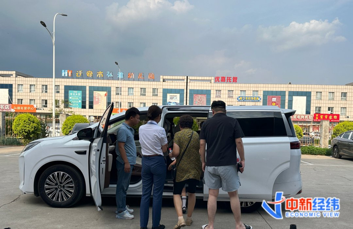 顾客带着全家试驾一款起售价近25万元的MPV 中新经纬摄
