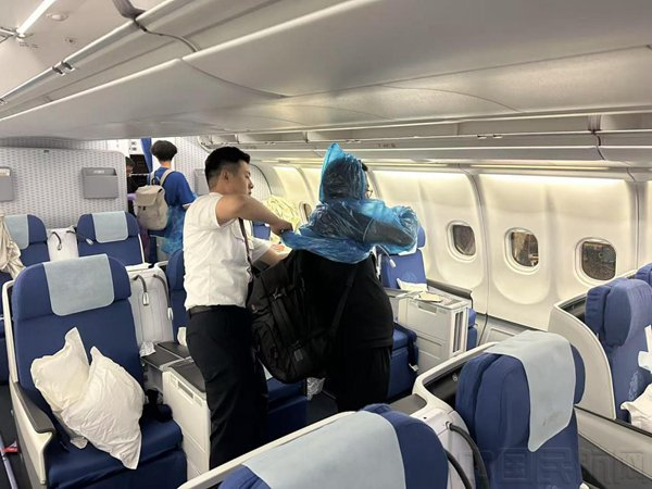 乘务组协助下机旅客穿好雨衣