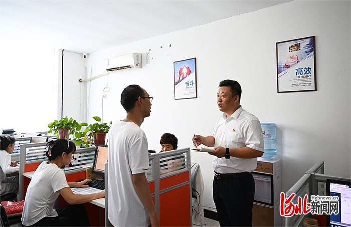 7月15日，齐晓鹏（右）在万创创业孵化基地征询对物业服务的意见和建议。河北日报记者 赵永辉摄