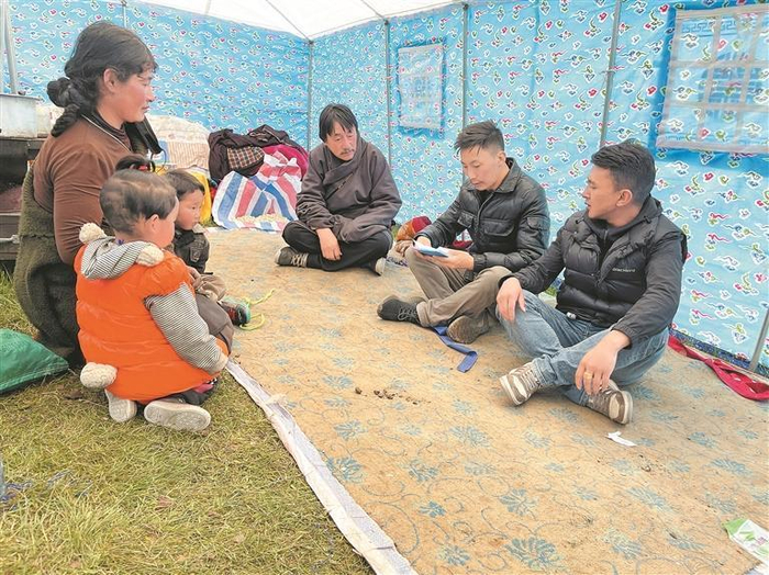 才让（右一）与村干部走访入户。本人供图