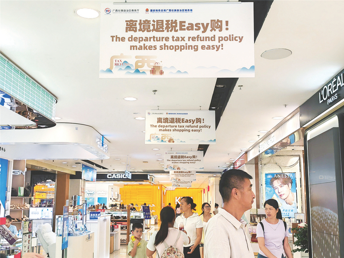     南宁百货大楼内挂着离境退税中英文宣传标语。本报记者韩沛 摄