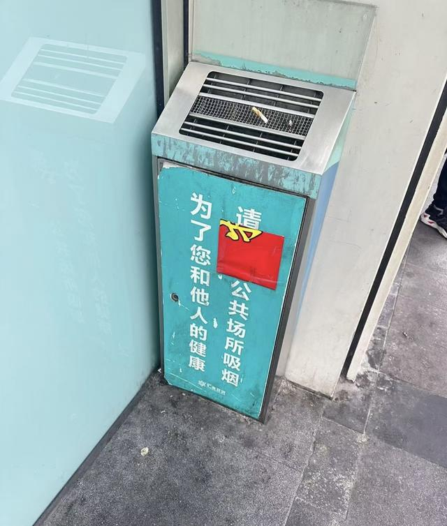 个别地铁口曾设置烟蒂投放点或带烟蒂收集的垃圾桶，成为烟民聚集的“吸烟点”，遭市民投诉后被撤走（网友供图）