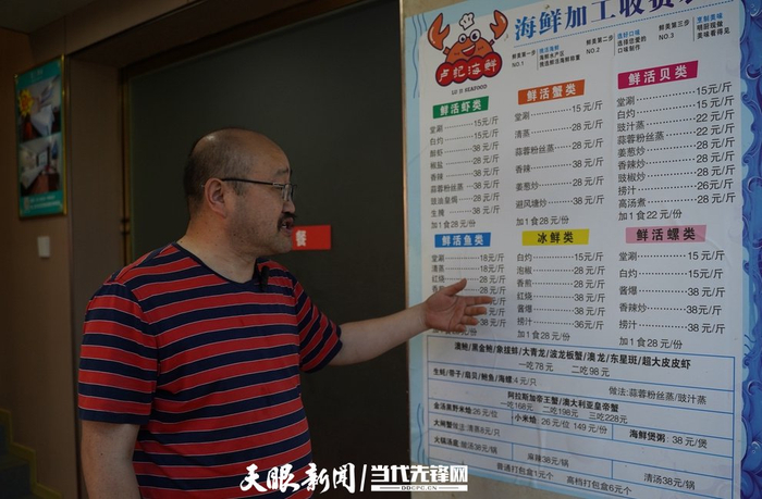 　　“卢记海鲜”老板卢必乙正在介绍店内菜单