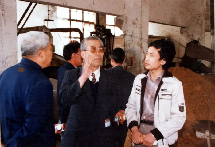 1988年，周恒刚到古井酒厂酿酒车间视察“北斗计划”实施情况。图源@古井集团