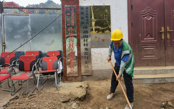 8月2日，孙胡沟村村委会前，救援人员在清理泥沙。新京报记者 周怀宗 摄
