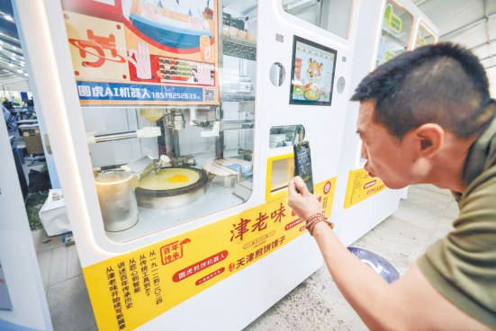 　　机器人“圆虎”正在摊煎饼。本报记者 邓伟 摄