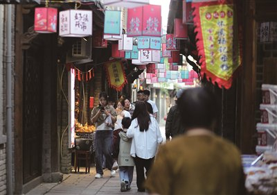 　　行人游逛平阳坡南街。翁卿仑 摄