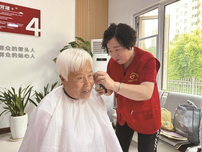     6月30日，在太平路街道中建城二社区，“老帮老”志愿者为社区老人义务理发。 常磊 摄