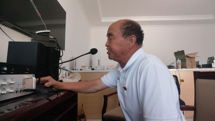 薄振林正在乡村大喇叭前广播，提醒村民回家后的注意事项。新京报记者 周怀宗 摄