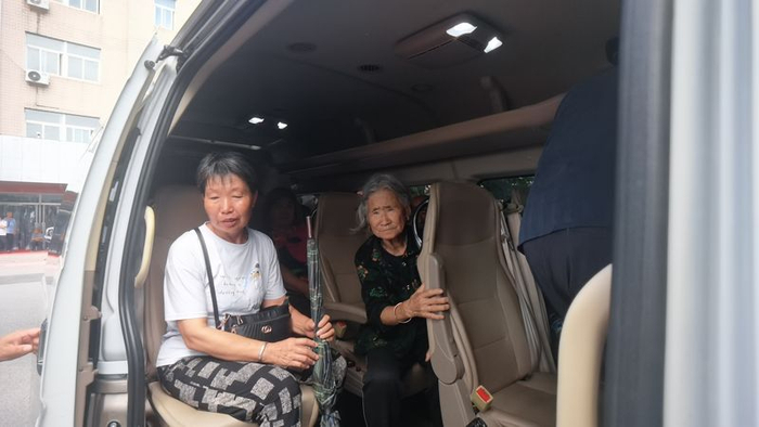 马继芹（左）坐上回家的车，等待发车的一刻。新京报记者 周怀宗 摄