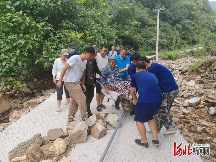 8月2日，下沉赵北沟村工作组和村干部用小推车转移村民王桂芝。 下沉赵北沟村工作组供图