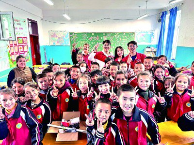 山东大学第26届研究生支教团3名成员与新疆吐鲁番于孜乡克伯克于孜小学学生们在一起。山东大学供图