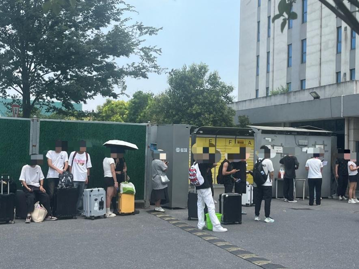 正在工厂外等候的应聘者。潮新闻 实习记者 马彩霞 摄