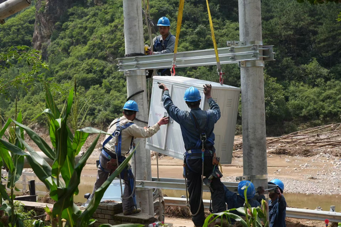 8月3日，国网北京门头沟供电公司支援团队在密云区北庄镇开展复电抢修。张文静 摄