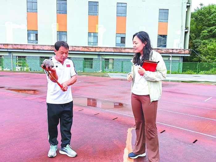 参加中老越三国丢包节陀螺比赛的江城县国庆乡嘎勒村村民张军海（左）向本报记者展示打陀螺的技法。陈丽婷摄