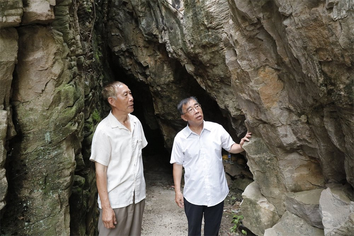 　　8月3日，在遵化鲁家峪村附近一烈士洞，李自亚（右）向鲁家峪陈列馆志愿者刘超（左）讲述当年母亲救助八路军情况。记者 师源摄