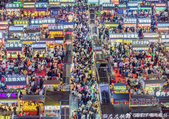 2024年4月21日，人们在正定县小商品夜市品尝美食（无人机照片）。新华社发（武志伟摄）