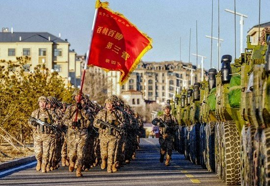 三营官兵手擎战旗、高喊口号奔赴训练场。（资料图）张永进/摄