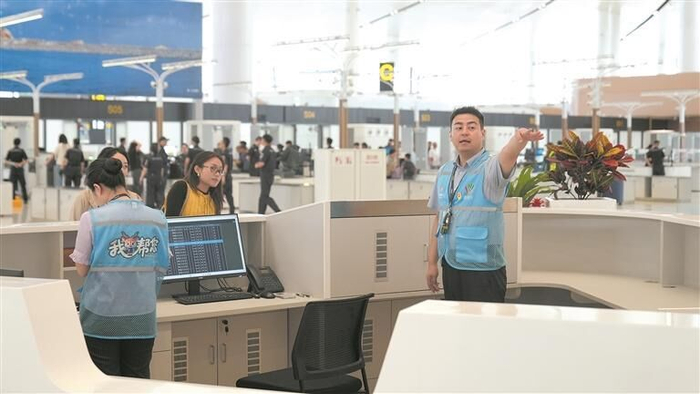 机场工作人员为旅客提供咨询服务。倪晓颖 摄