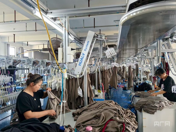 丰卓服饰生产车间里，缝制工正在生产运动服（央广网记者张琳琳  摄）