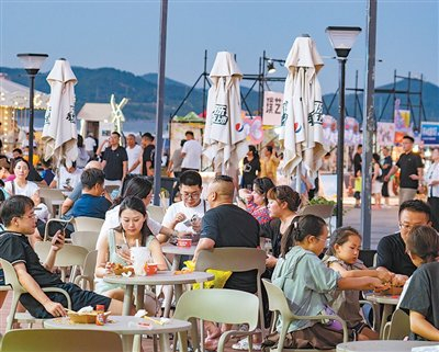 　　山东青岛西海岸新区金沙滩，游客在品尝美食。刘元波摄