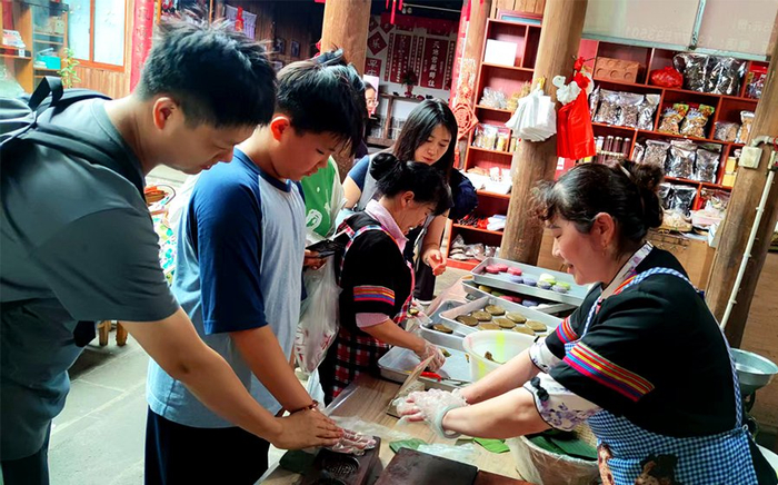 游客体验大米粑粑制作技艺（8月6日摄）。新华网发（韩文萍 摄）