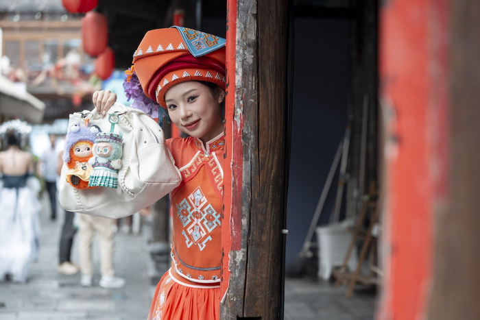 7月8日，在湖北省恩施土家族苗族自治州，一名穿着土家传统民族服饰的女子在展示穿上西兰卡普的拉布布。新华社记者 伍志尊 摄