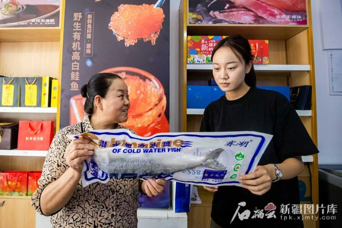 在赛里木湖经营特产店的商户向游客推荐特色产品。（资料图）楠登摄