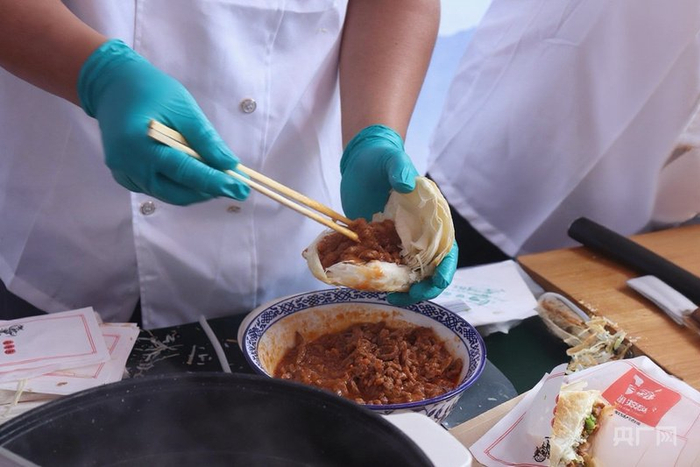工作人员现场制作肉夹馍（央广网发  实习记者苏睿楠  摄）
