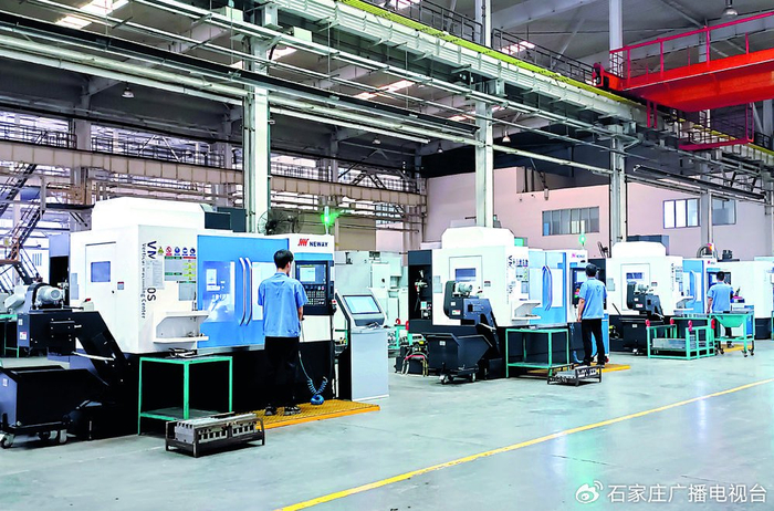 石煤机公司的职工操作数控机床对产品部件进行精密加工。