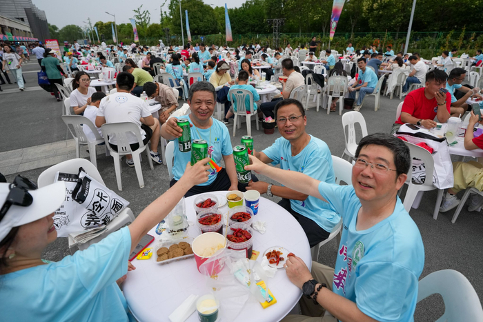 球迷在江苏淮安“苏超”市集品尝美食特产。新华社记者 李博 摄