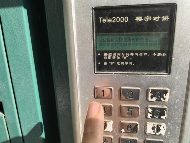 图为万馨佳园72号楼的门禁设备。尽管通着电，但不管记者输入哪个户号，屏幕上均显示“ERR”的错误提示。