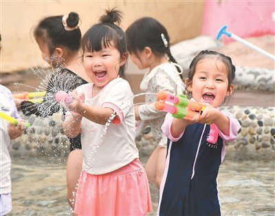 图为8月6日，在河北省邯郸市永年区临洺关镇金典社区爱德堡幼儿园，小朋友正在打水仗。胡高雷摄（人民视觉）