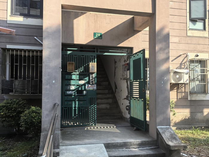 门禁“瘫痪”后，万馨佳园物业将楼道大门打开后并用石块抵着。